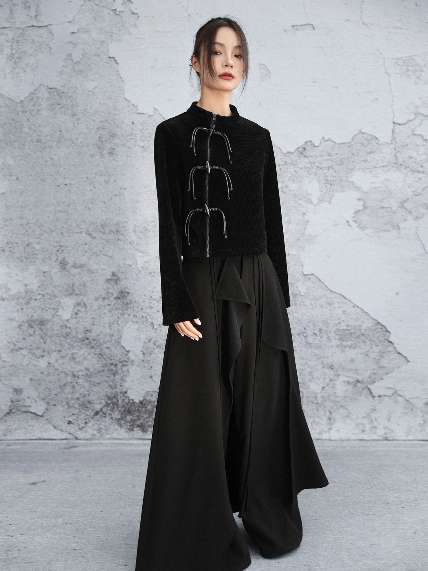 Full-body side-front view of a black modern Hanfu chenille sweater paired with flowing wide-leg black trousers in a minimalist monochrome outfit
