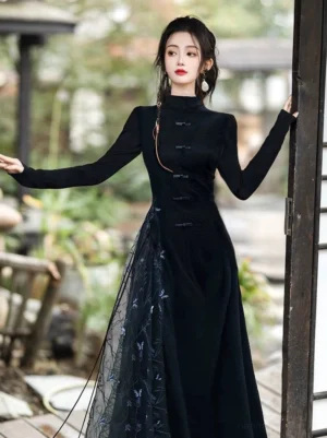 Three-quarter view of a black modern Hanfu inspired cheongsam dress with fitted silhouette frog buttons and embroidered blue tulle side panel