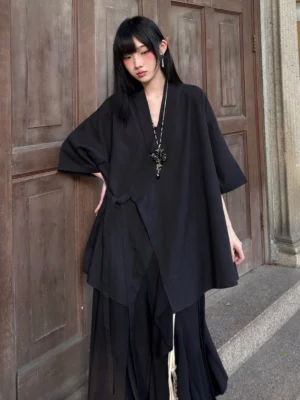 Three-quarter view of a black modern Hanfu cross-collar cardigan with loose draped silhouette and relaxed half-sleeve design