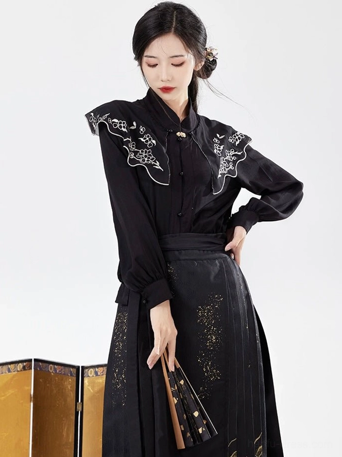 Close three-quarter view of black modern Hanfu top with floral embroidered cloud collar and black gold mamianqun skirt