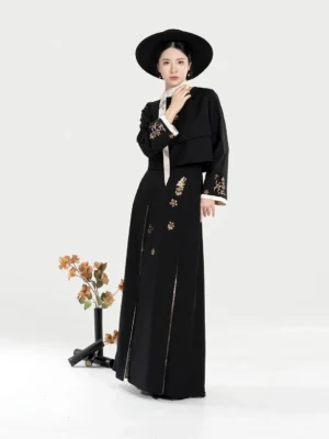 Front view of a black modern Hanfu two-piece outfit with golden phoenix-inspired floral embroidery, cropped stand-collar jacket, pleated skirt, and white contrast trim