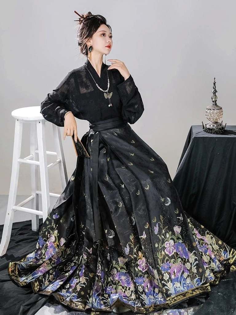 Black pleated mamianqun horse face skirt showing the wide floral printed hem border and flowing silhouette
