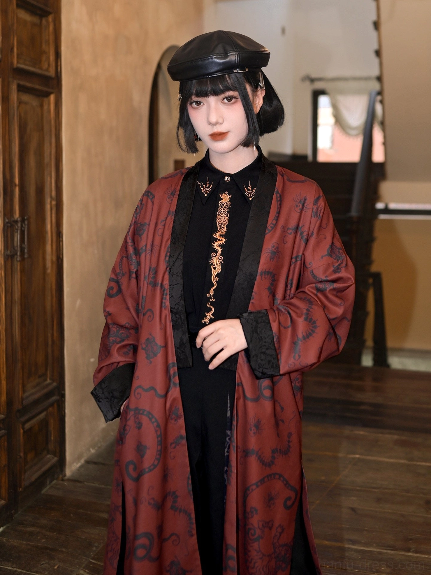 Three-quarter front view of a black and red modern Hanfu coat with Five Poisons inspired vintage pattern, side hem slits, and long flowing design