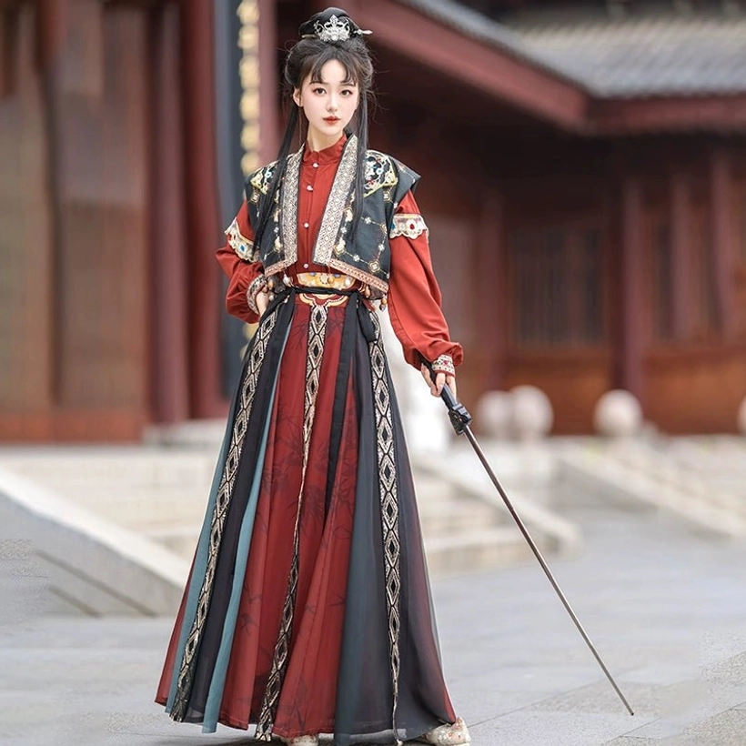 Full black and red Tang Dynasty hanfu swordsman outfit with gold-trimmed embroidered vest layered skirt and long sword in a traditional courtyard