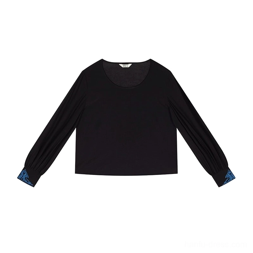 Flat lay of a black round collar hanfu inner top with long lantern sleeves and contrasting teal cuffs