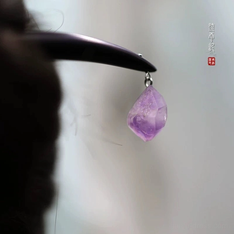 Close-up of natural purple amethyst pendant and silver-tone connecting ring on black wooden Chinese hair stick