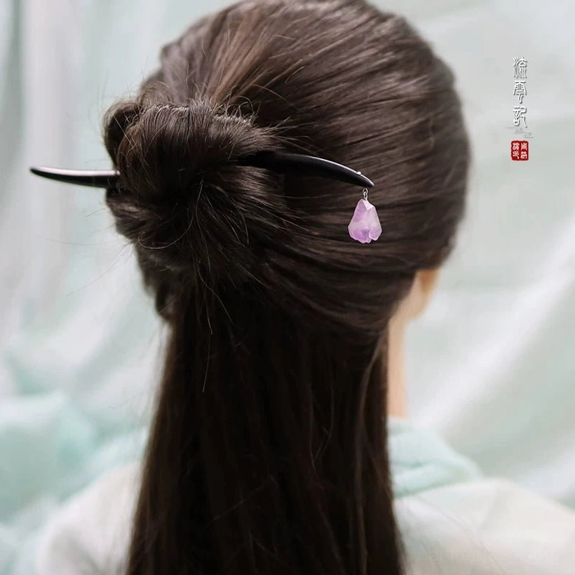 Back view of black sandalwood amethyst Chinese hair stick securing a low bun hairstyle with purple pendant hanging below