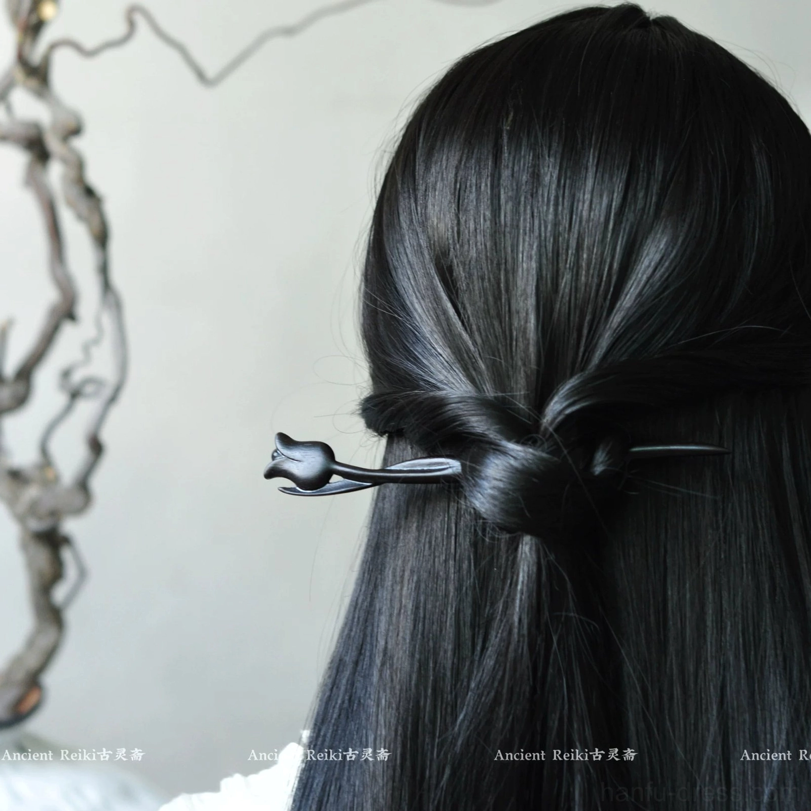 Black tulip Chinese hair stick worn in a sleek half-up half-down hairstyle with a carved flower ornament visible from the back