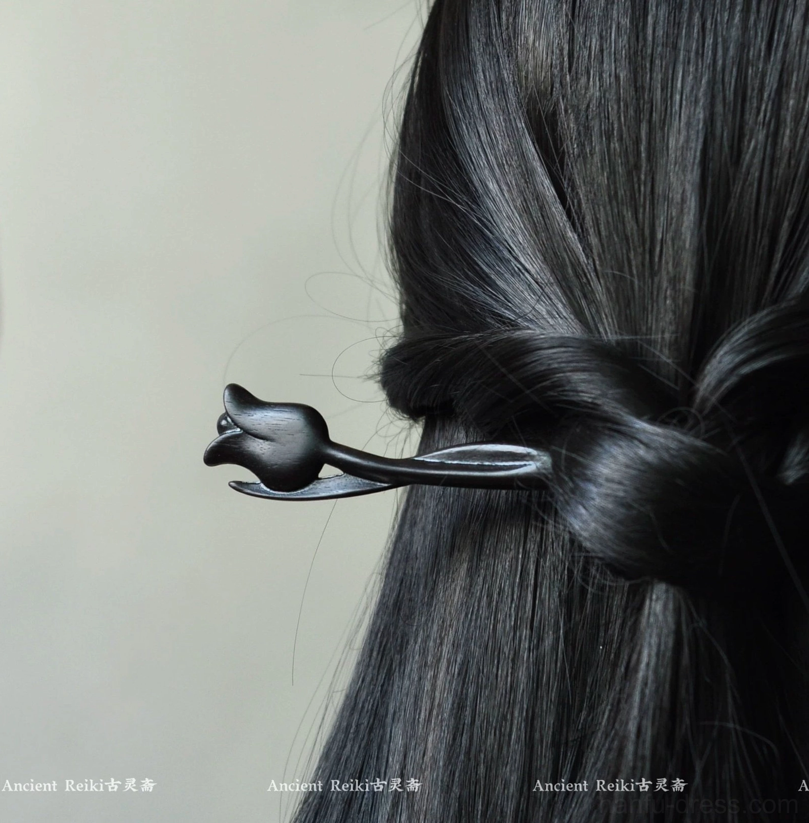 Side back view of a black tulip wooden hair stick securing straight long hair in an elegant half-up Hanfu-inspired hairstyle
