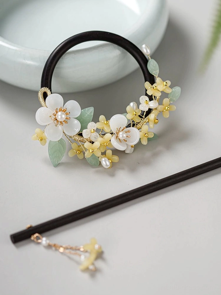 Close-up view of a black wooden circular Hanfu hair ornament with floral decorations pearl details and separate tassel hair stick