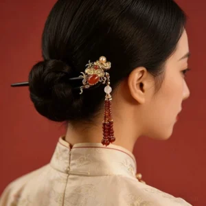 Blooming cloud Chinese hair stick worn in a coiled bun with red beaded tassel and gold-tone cloud ornament