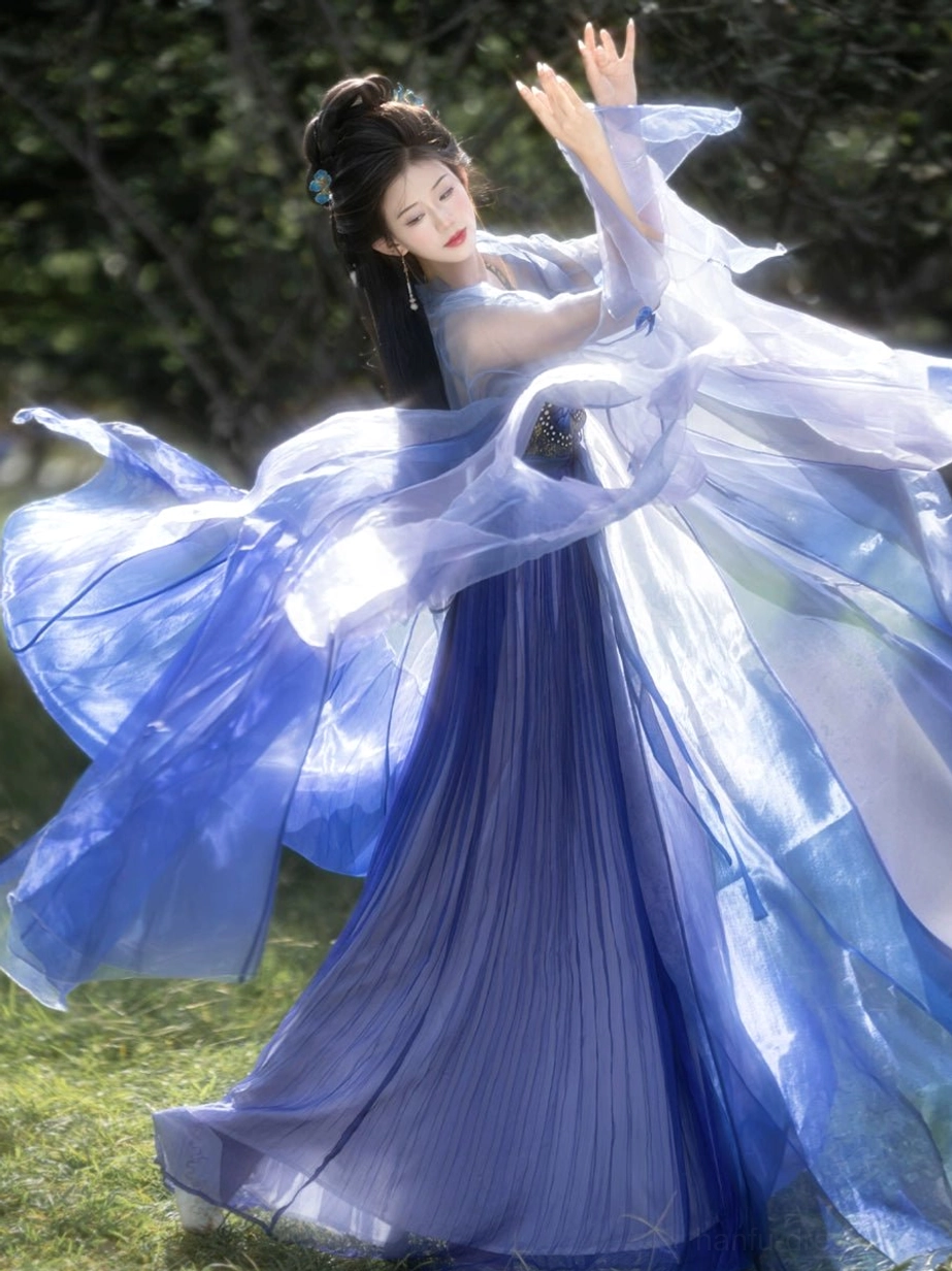 Blue butterfly Tang-style Hanfu Heziqun viewed from the back with wind-blown translucent gradient layers, oversized flowing sleeves, floor-length deep blue pleated skirt, and elegant trailing fabric