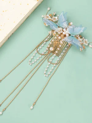 Blue butterfly tassel Chinese Hanfu hair comb displayed on a mint green background with gold-tone comb teeth and pearl floral details