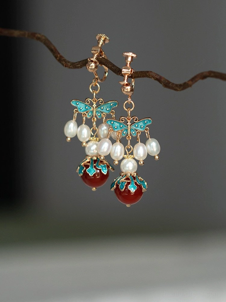 Clip-on Chinese butterfly earrings featuring blue cloisonne wings pearl bead details and red agate hanging drops
