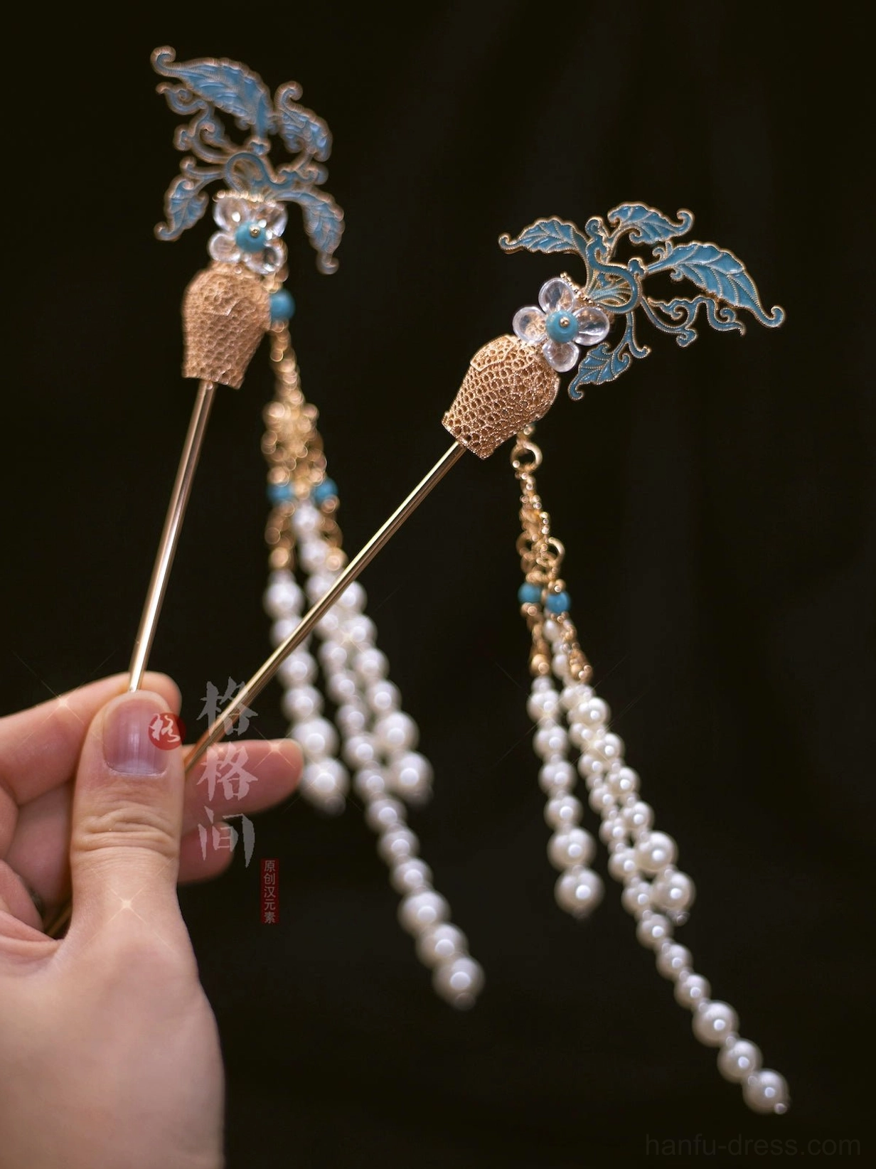 Close up of blue cloisonne style leaves gold floral accents and long pearl tassels on Chinese Hanfu hair pins