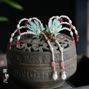 Blue cloisonne phoenix hanfu hairpins with pearl tassels displayed on a carved antique incense burner