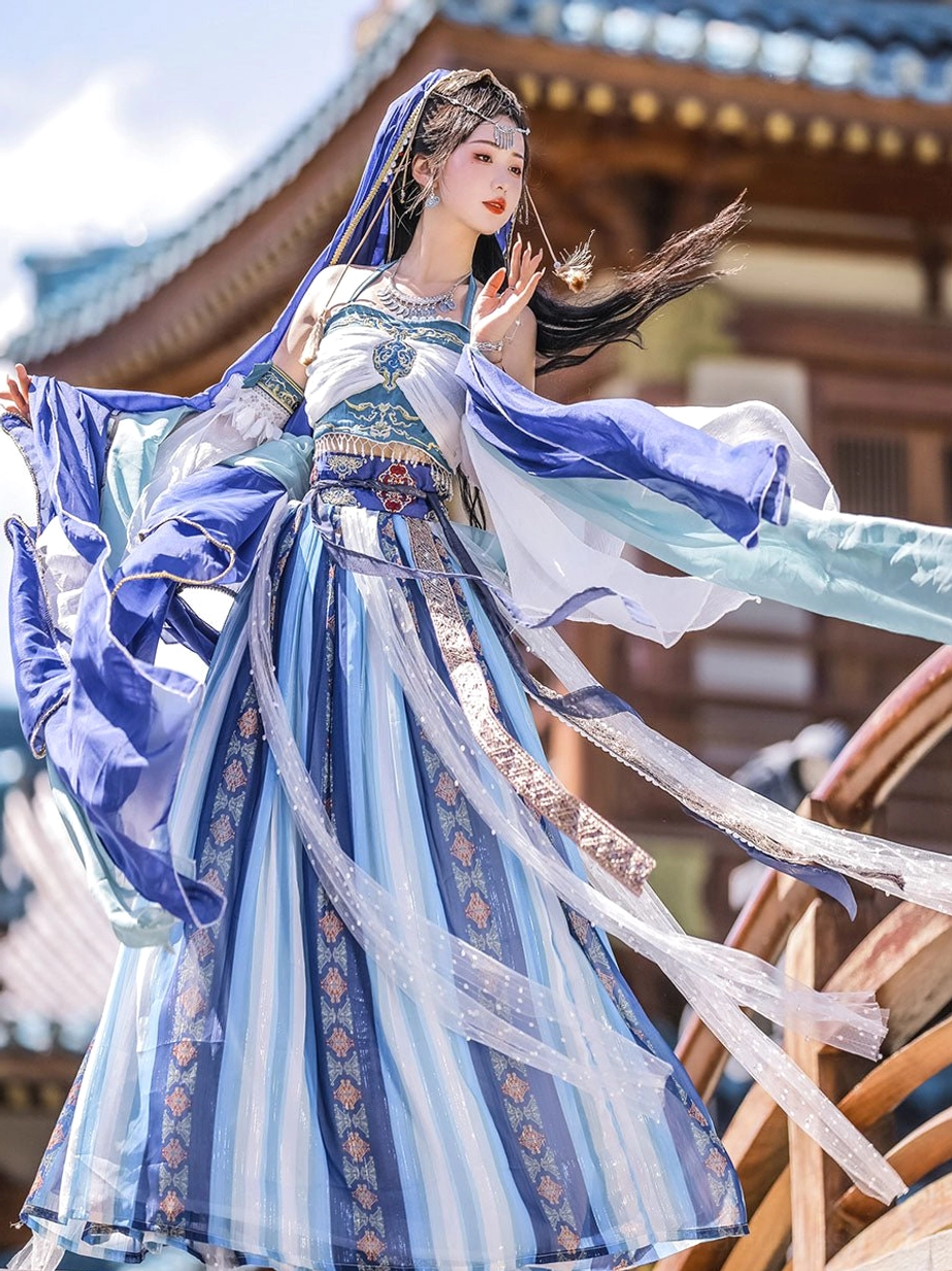 Side view of blue and cyan Dunhuang Feitian Tang Dynasty Hanfu dress with flowing silk ribbons, striped pleated skirt, matching veil, and graceful movement in a traditional Chinese courtyard