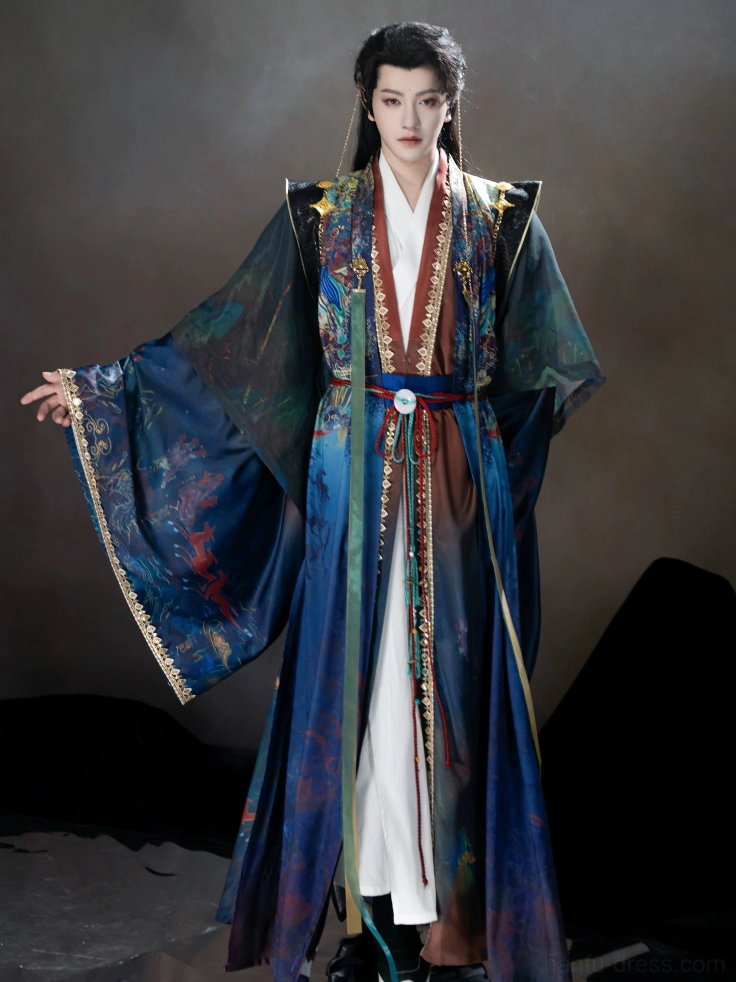 Full-length side view of a blue male Dunhuang Xianxia Hanfu showing the dramatic wide sleeves, white inner garment, golden cuff trim, and flowing robe silhouette