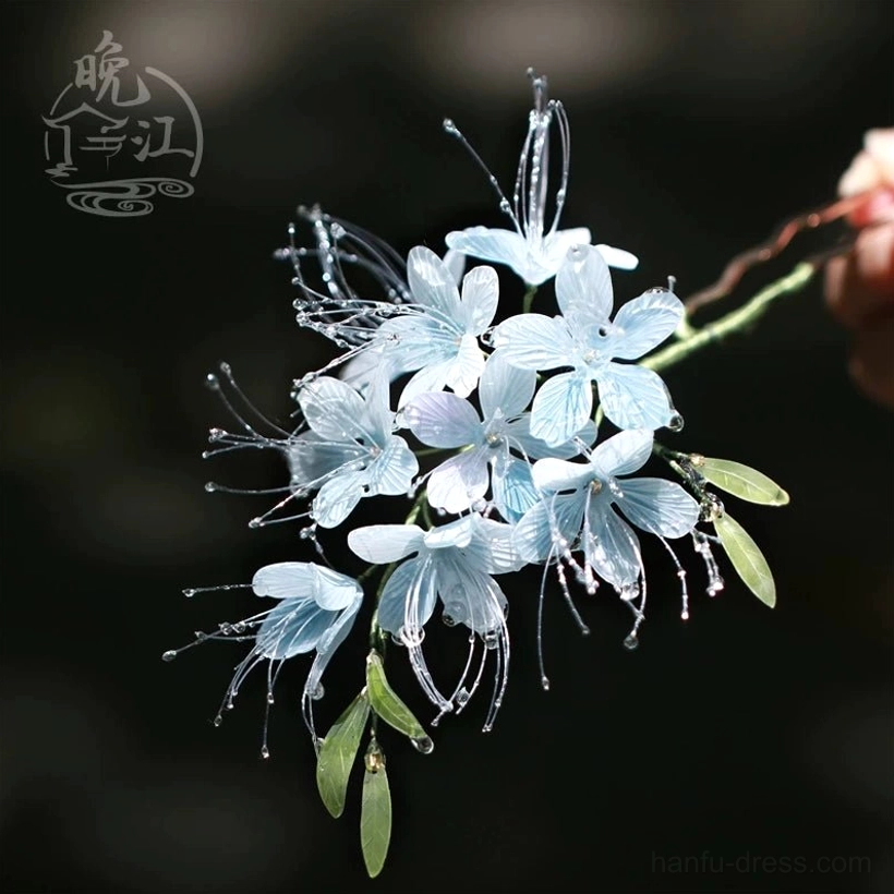 Blue floral Chinese hair accessory held in hand showing the detailed flower cluster green leaf accents and delicate traditional Hanfu hair styling design