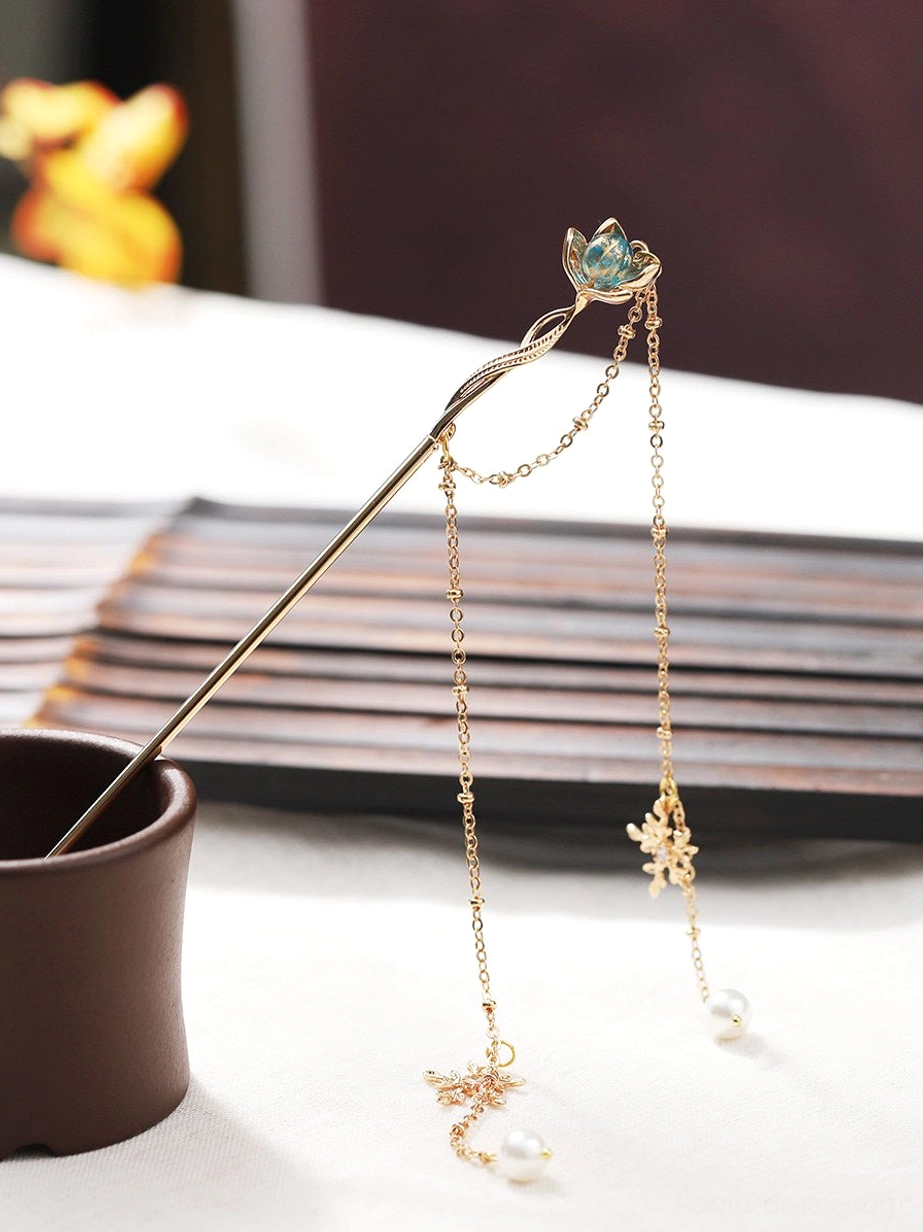 Blue gradient lotus Hanfu hair stick displayed from the side with flowing gold-tone tassel chains, pearl drops, and snowflake-shaped charms