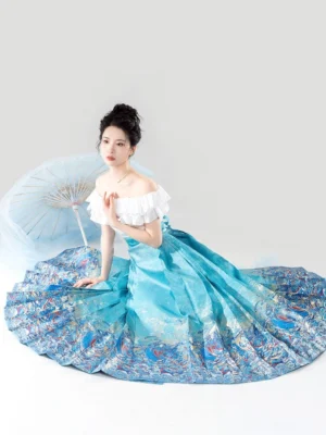 Seated overhead view of a modern Hanfu-inspired outfit with a white off-shoulder ruffle blouse and wide pleated blue Mamian skirt spread to show its decorative hem