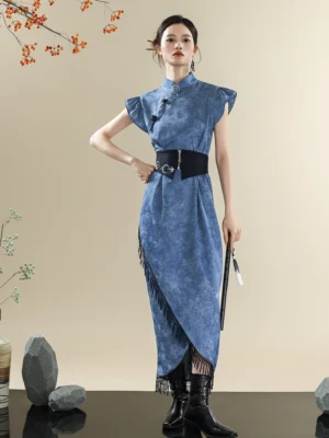 Three-quarter view of a blue marbled tie-dye qipao dress with traditional Chinese frog fasteners, wrap-style asymmetrical hem, side tassels, and silver-detail waist belt