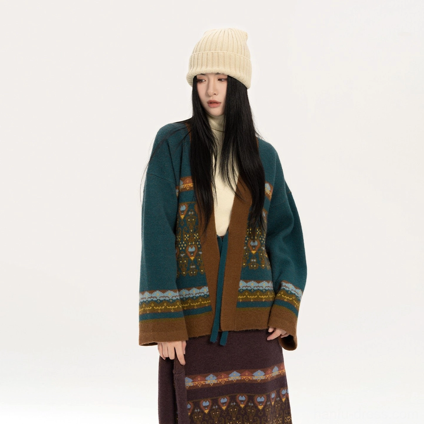Close-up view of blue modern Hanfu knit cardigan and matching jacquard midi skirt with detailed trim and fringe hem