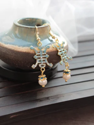 Blue enamel Shou character longevity Chinese drop earrings with white pearl style pendants on ceramic jar