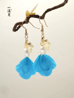 Front view of blue velvet flower Hanfu earrings featuring layered gold maple leaf charms and pearl-like bead drops on a branch