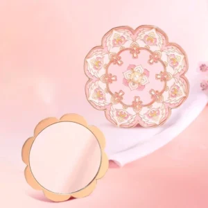 Blushing lotus blossom Chinese pocket mirror shown open and closed on a warm pink background, featuring a reflective mirror face and ornate pink floral back cover with rose gold-tone scalloped frame