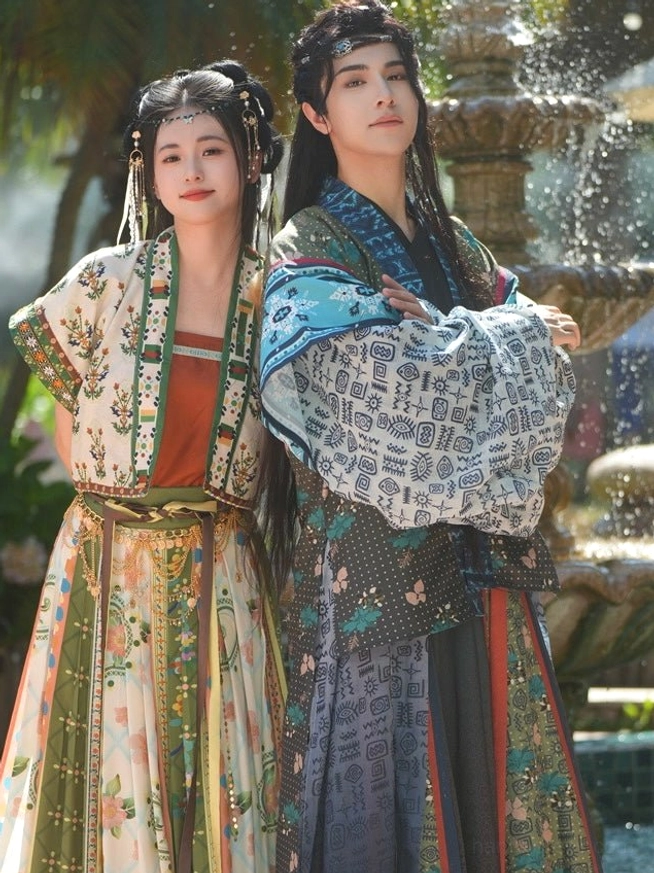 Back three-quarter view of Bodhi Tang-style couple hanfu showing patterned male banbi and female cropped top