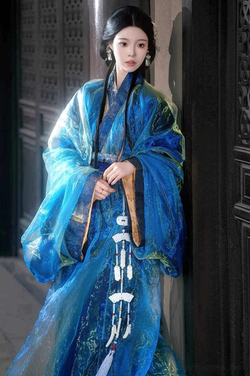 Three-quarter front view of a bright blue shiny sheer Han Dynasty Hanfu robe with gold-trimmed sleeve cuffs and long hanging white jade-style tassels
