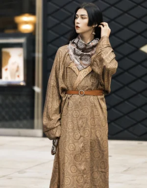 Front three quarter view of a brown Tang Dynasty Hanfu robe with textured jacquard cross collar design leather belt printed scarf and hanging hem accessory