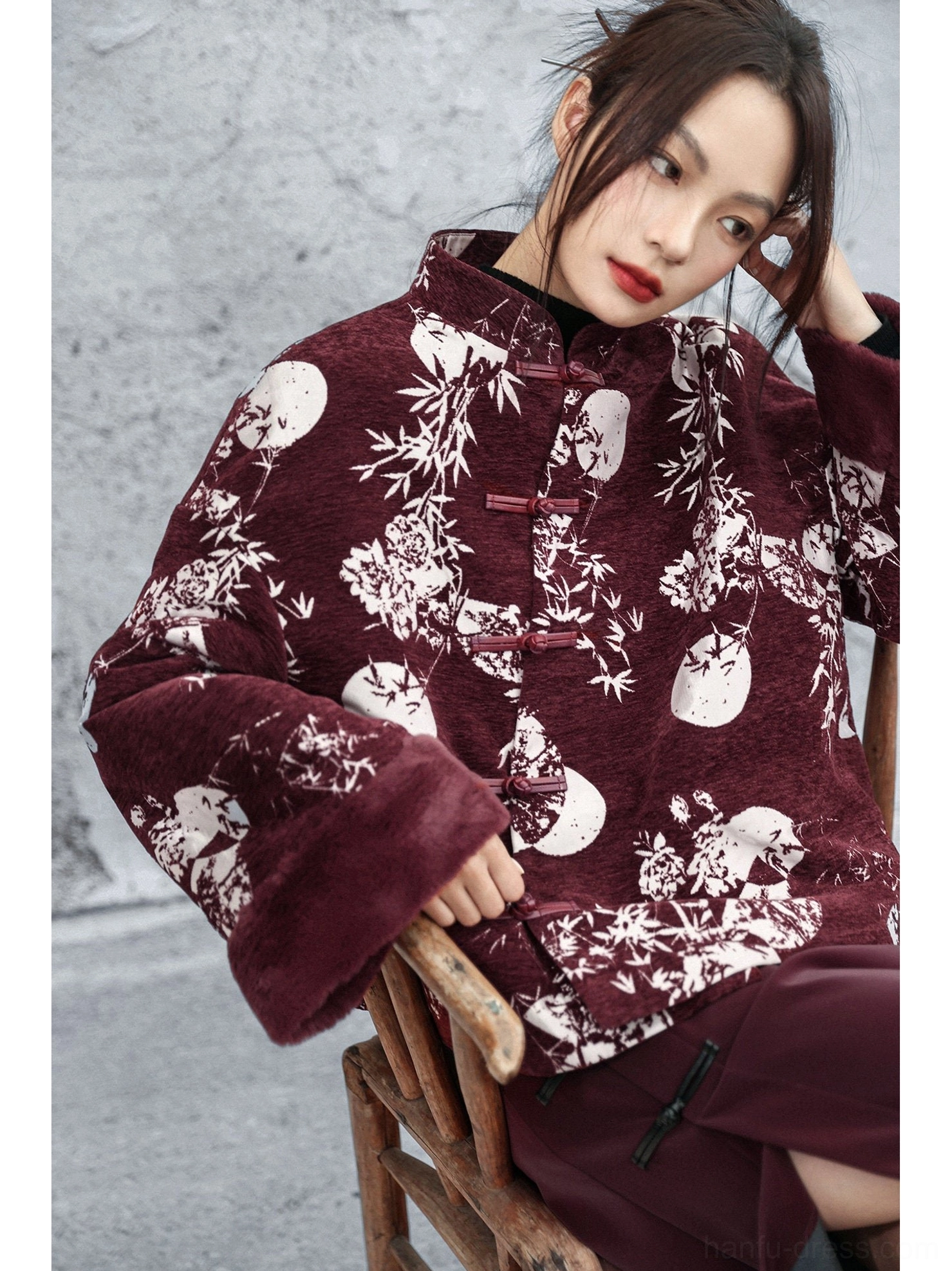 Close-up of burgundy modern Hanfu winter jacket showing chenille fabric texture, bamboo and full moon floral print, frog fasteners, and fuzzy sleeve cuffs