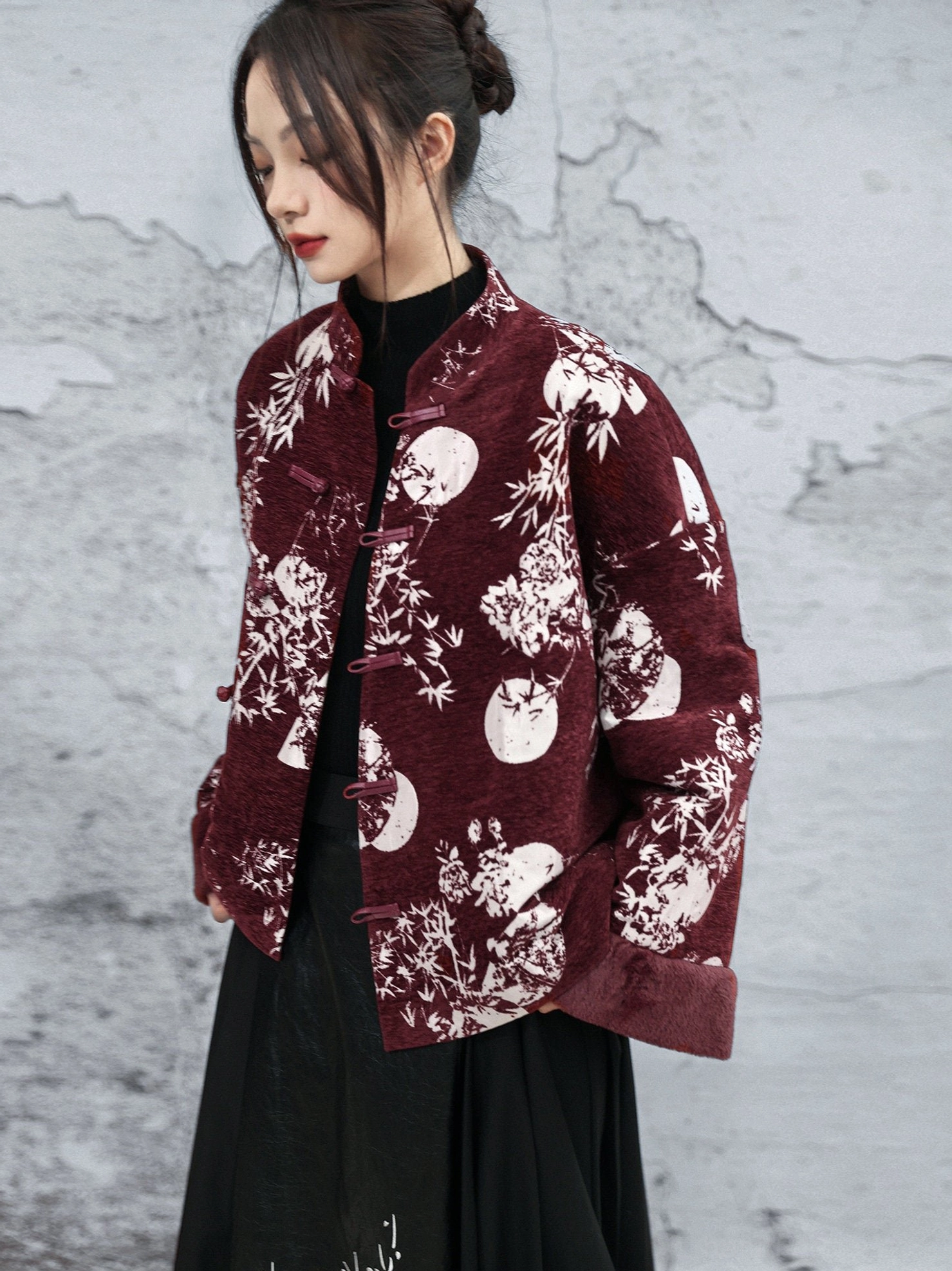 Chinese-style burgundy chenille winter jacket layered over black turtleneck and long skirt, featuring frog buttons, stand collar, and traditional floral print