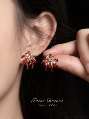 Burgundy firework Chinese earrings worn on model ear, gold-tone Hanfu jewelry with sparkling crystal center
