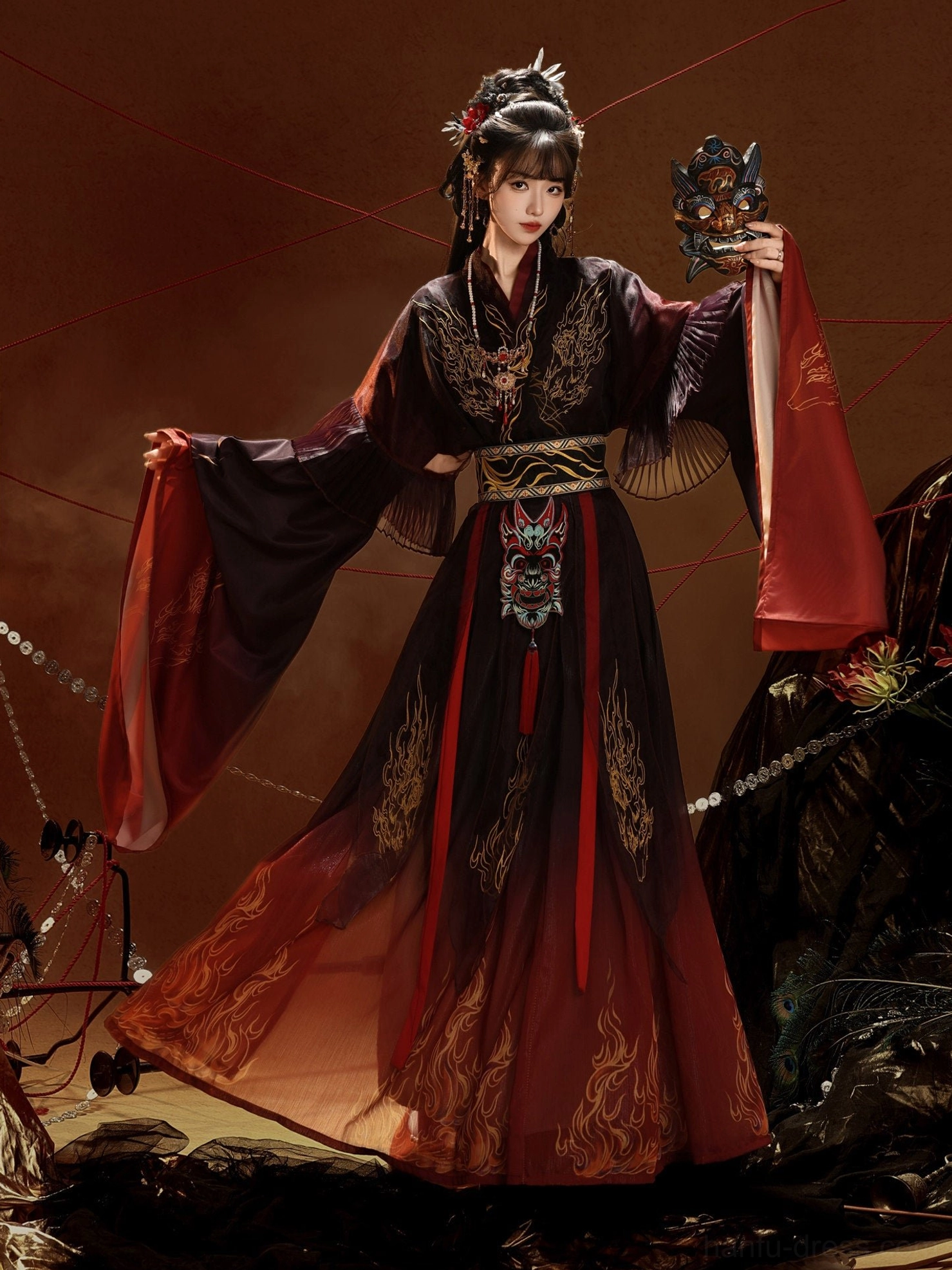 Burning Skies Wei Jin Dynasty Nuo opera inspired embroidered Hanfu full set shown from a front three-quarter view with black to red gradient skirt, gold flame embroidery, wide layered sleeves, and decorative waist accessories