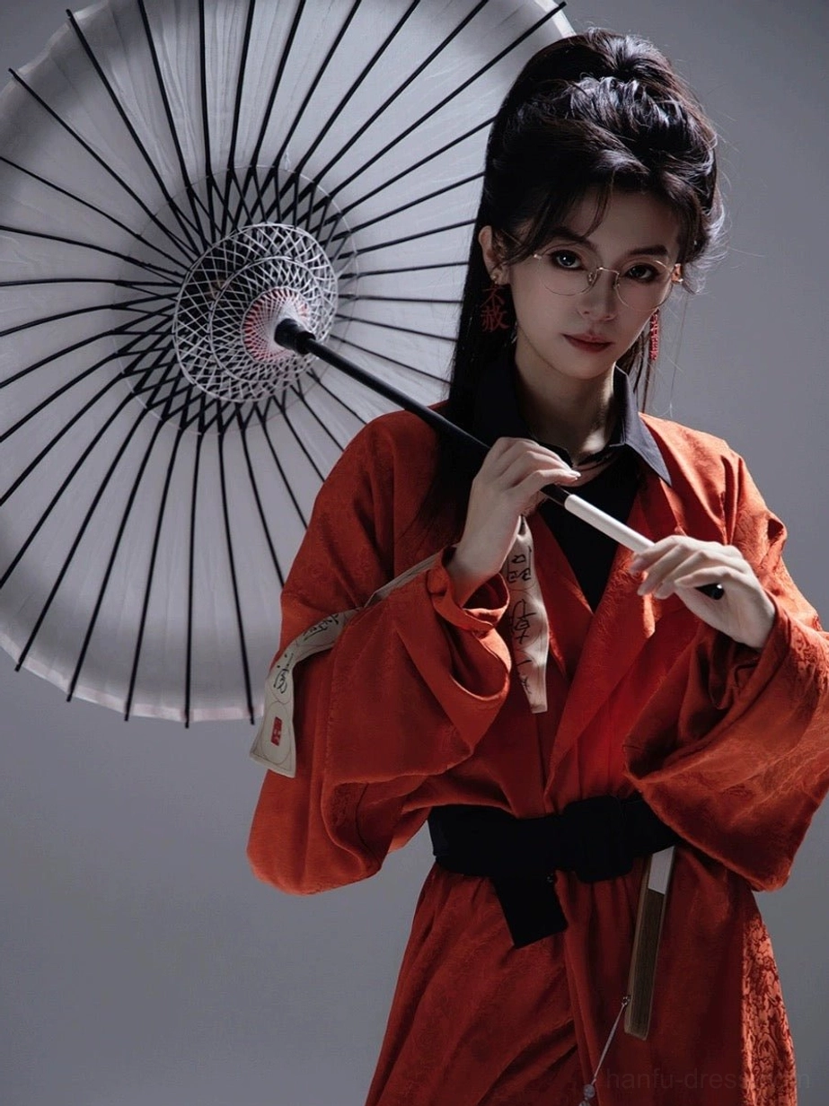 Close view of satin texture on burnt orange Tang Dynasty Hanfu robe with black waist sash in wuxia inspired styling
