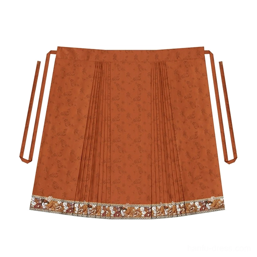 Flat lay of a burnt orange traditional Chinese mamianqun skirt with central pleats, waist ties, floral woven texture, and embroidered brocade hem