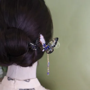 Butterfly Chinese hair stick with glittering ornament and blue gold beaded tassel displayed in a low twisted Hanfu updo