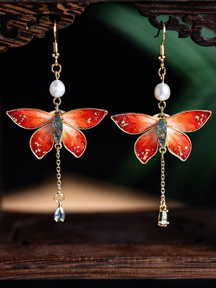 Butterfly tassel drop Chinese earrings with gold-tone hardware, freshwater pearl accents, crystal pendants, and elegant mixed pendant details on a carved wooden display stand