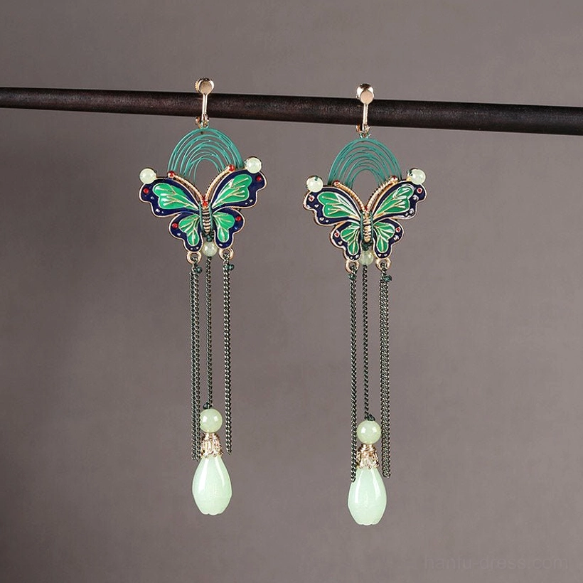 Pair of butterfly teardrop comfort clip on earrings with green blue enamel details black chains and jade style pendants