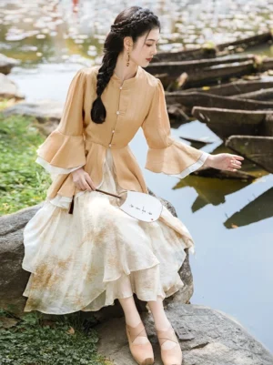 Canary yellow modern Ming style Hanfu two-piece outfit with ruffle sleeve stand collar top and beige gradient midi skirt worn beside a lakeside garden