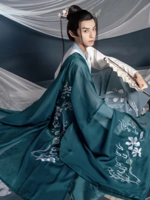 Rear three quarter view of teal wuxia style male hanfu showing embroidered cloud and floral motifs across the flowing wide sleeve outer robe