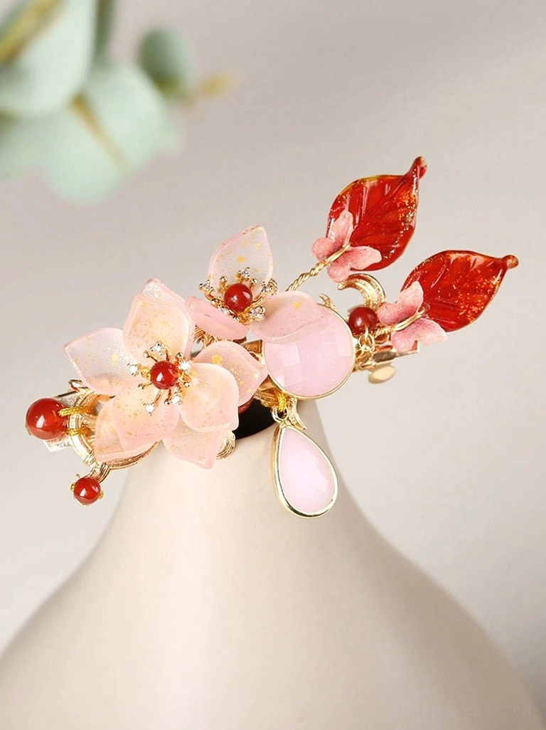 Close-up of carmine pink floral Chinese hair accessory with gold-tone frame red enamel leaves beads and teardrop charm