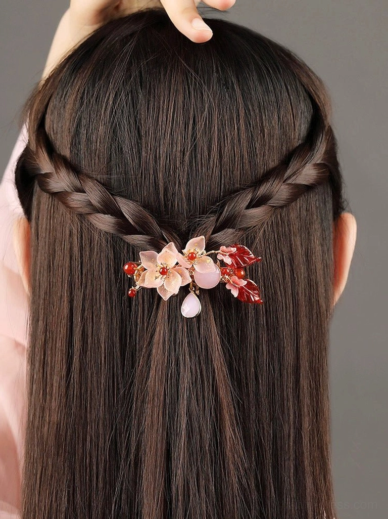 Carmine floral Chinese hair pin decorating crossed half-up braids at the back of a woman's hairstyle