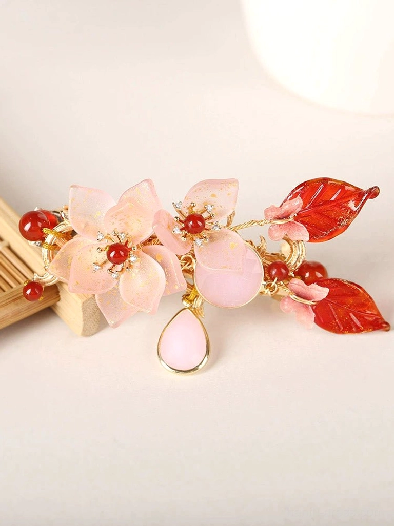 Flat lay of pink and red floral hanfu back hair pin with gold-tone hardware and dangling pink teardrop pendant