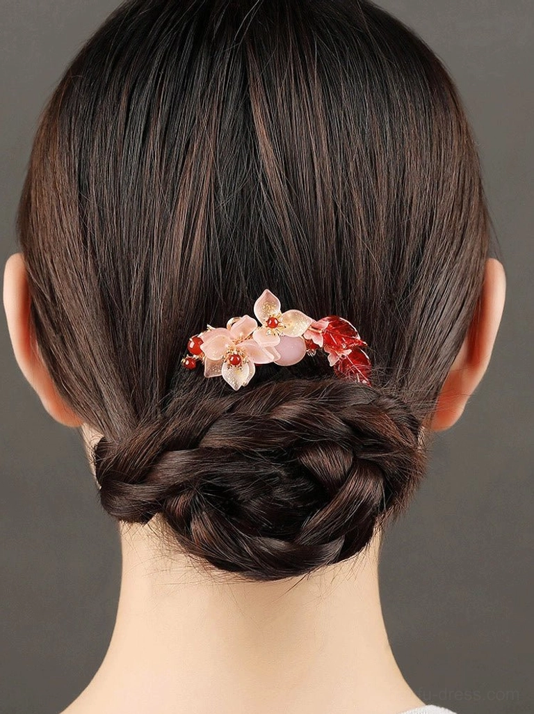 Pink floral Chinese hanfu back hair pin placed on a low braided chignon hairstyle with dangling teardrop charm