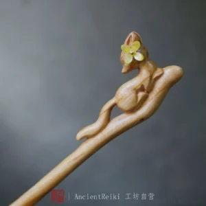 Front view of a carved wooden fox Hanfu hair accessory resting on a branch-shaped hair stick with a yellow flower accent