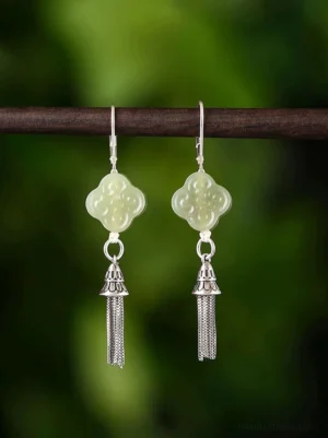 Celadon four-leaf clover tassel Chinese earrings with sterling silver hook and vintage filigree detail displayed on wooden rod